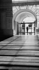 Rear view of man walking in corridor of building