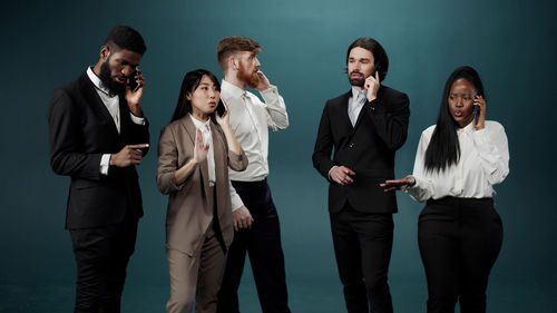 Business colleagues standing against colored background