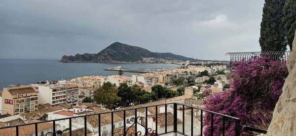 Scenic view of sea by city against sky