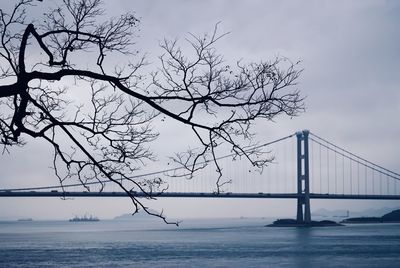 View of suspension bridge over sea against sky