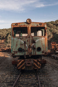 Abandoned train on railroad track against sky