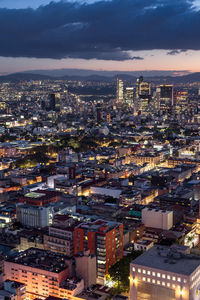 Aerial view of illuminated cityscape against sky at night