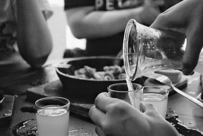 Cropped hands pouring drink