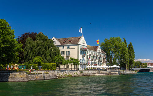 Buildings at waterfront against blue sky