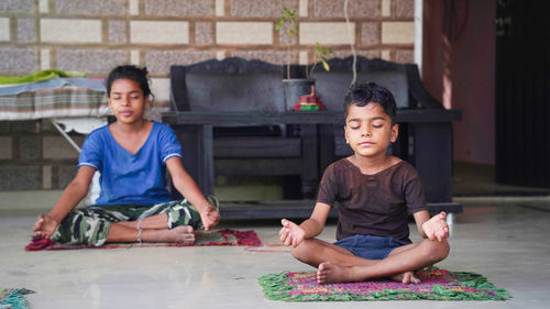 Asian kids doing yoga pose at home. group of children doing gymnastic exercises.