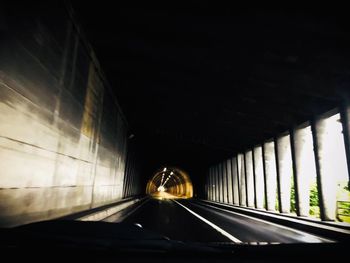 Illuminated tunnel seen through car windshield