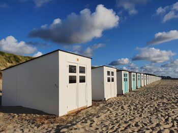 Buildings on beach against sky during sunny day