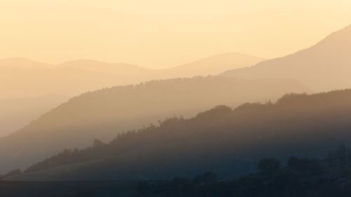 Scenic view of silhouette mountains against sky during sunset