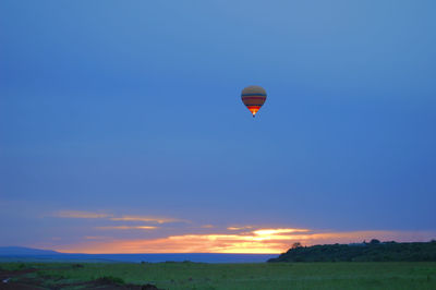 Hot air balloon flying in sky during sunrise