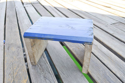 Close-up of blue stool on floorboard