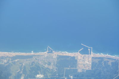 Windmill on mountain against clear blue sky