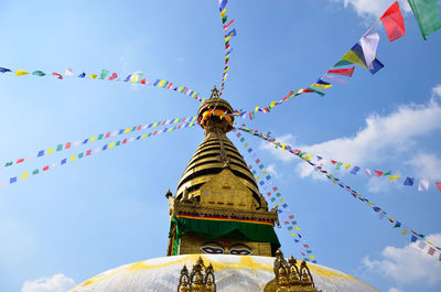 Low angle view of prayer flags on temple against sky
