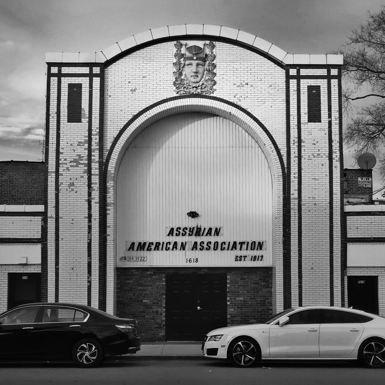 car, transportation, arch, built structure, text, architecture, land vehicle, building exterior, mode of transport, day, outdoors, no people, city, sky