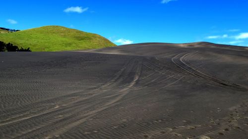 Scenic view of desert against blue sky