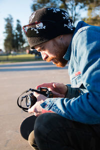 Side view of young man looking at camera