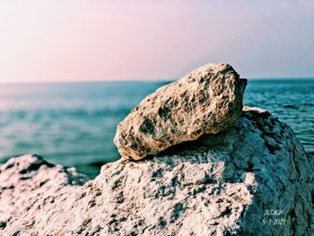 Close-up of rocks on shore against sea