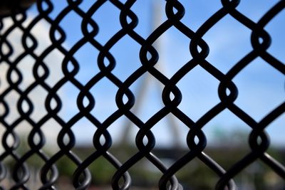 Close-up of chainlink fence against sky