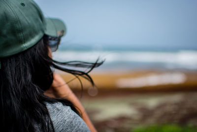 Rear view of woman wearing hat against sea