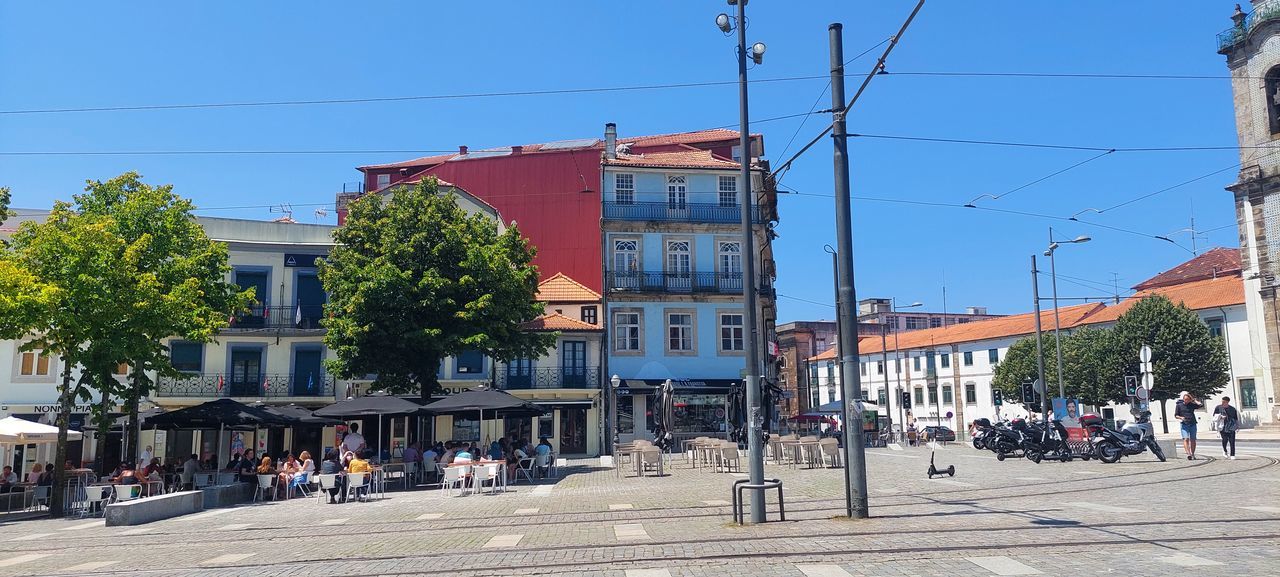 GROUP OF PEOPLE ON STREET AGAINST BUILDINGS