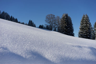 Snow covered land against clear sky