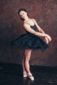 Portrait of woman dancing against wall