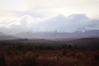 Scenic view of mountains against cloudy sky