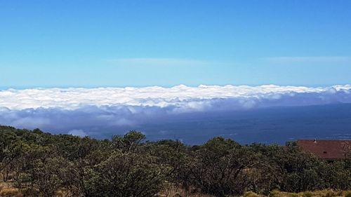 Scenic view of sea and mountains against blue sky