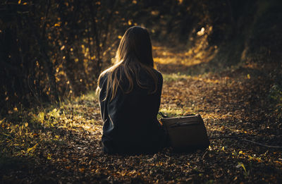 Rear view of woman sitting outdoors