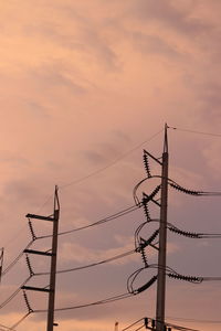 Low angle view of silhouette electricity pylon against sky during sunset