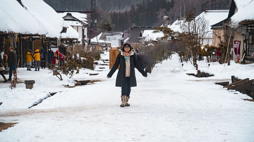 Rear view of man walking on snow