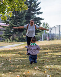 Full length of mother and son playing at park