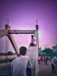 Rear view of people walking in city against clear sky