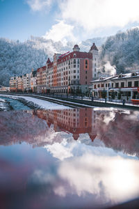 Reflection of buildings in lake against sky