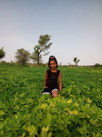 Portrait of girl amidst plants on field