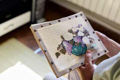 High angle view of senior women sewing at home next to sunny window