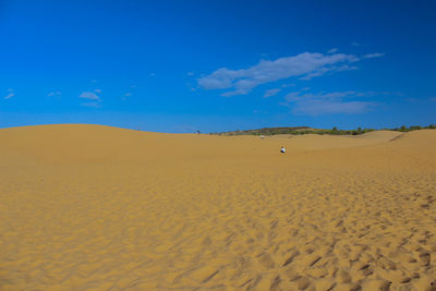 Scenic view of desert against blue sky