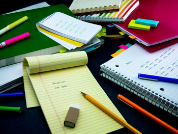 High angle view of note pad with pencil and eraser on desk