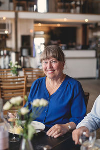 Portrait of smiling senior woman having lunch and socializing in restaurant