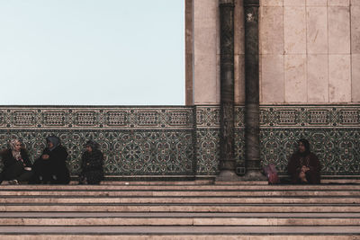 People at temple against building