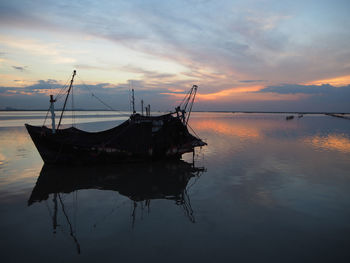 Sailboats in sea against sky during sunset