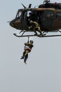 Low angle view of helicopter flying against clear sky