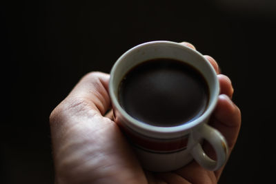 Close-up of hand holding coffee cup