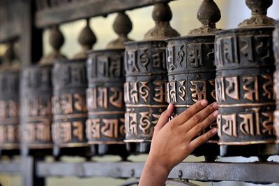Cropped image of person touching prayer wheel