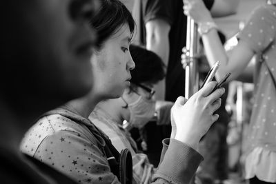 Young woman using mobile phone while traveling in train