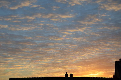 Low angle view of built structure against sky at sunset