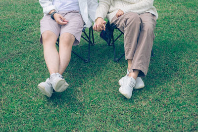 Low section of woman sitting on grassy field