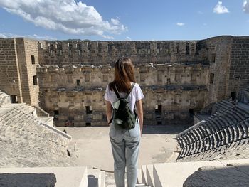 Rear view of woman standing against the building