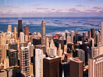 Aerial view of cityscape against cloudy sky