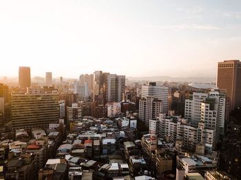 Aerial view of buildings in city against clear sky