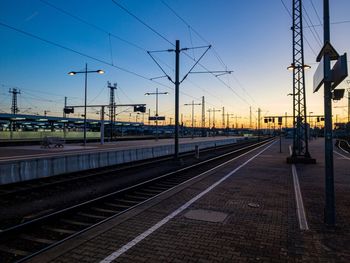 Railroad tracks against sky at sunset